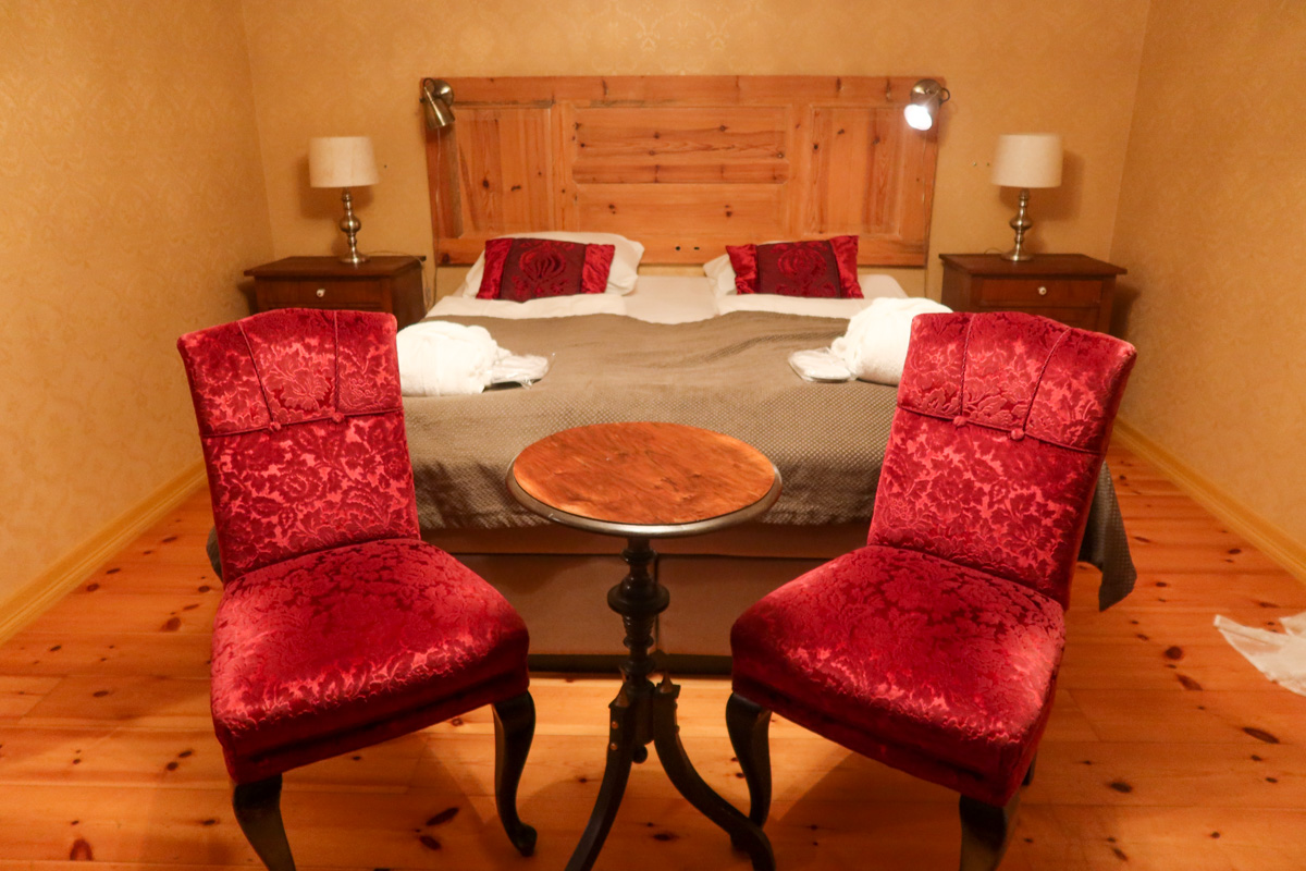 Comfortable bed in the Fretheim Hotel in Flam with chairs in front