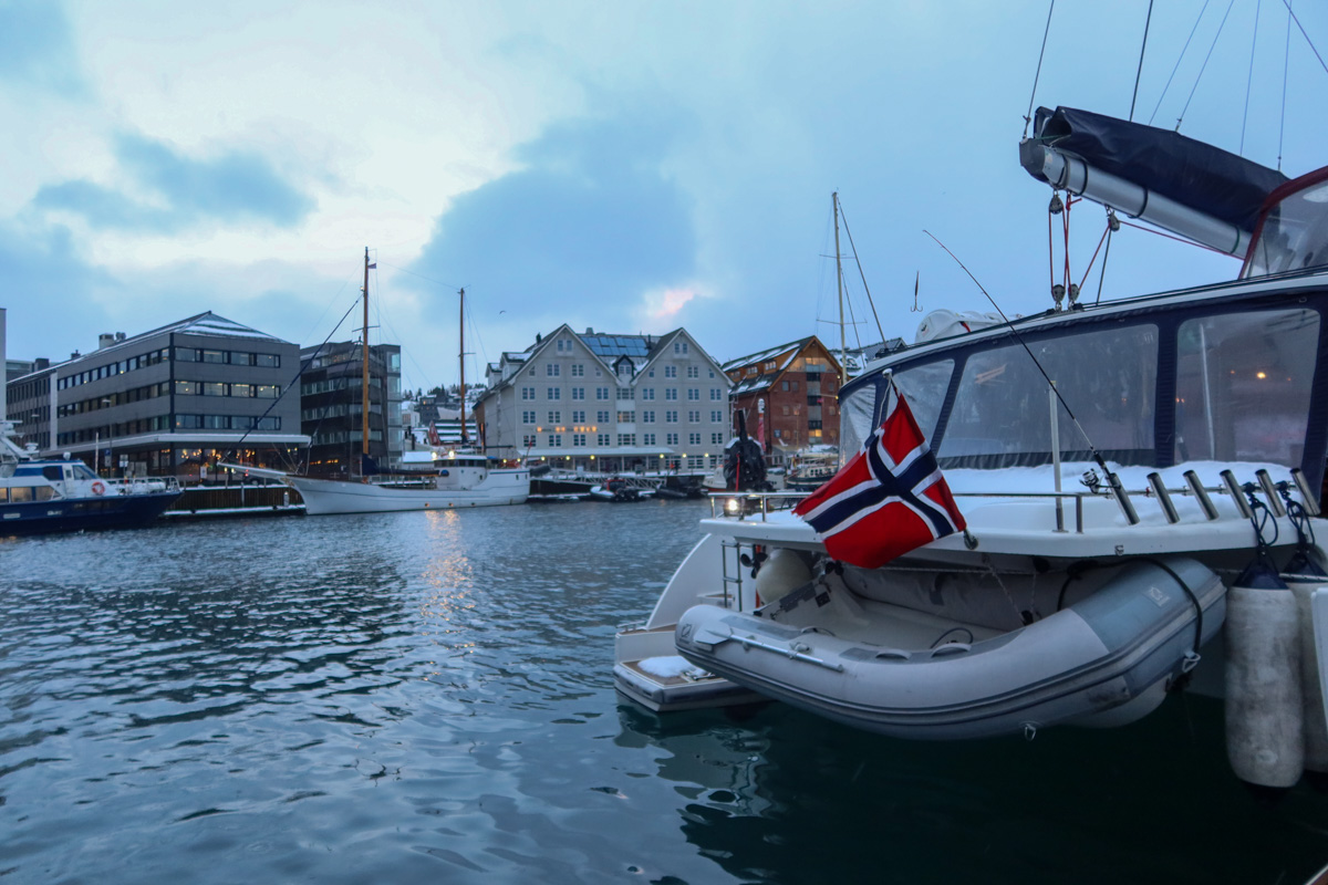 Boat with norwegian flag in Tromso harbour
