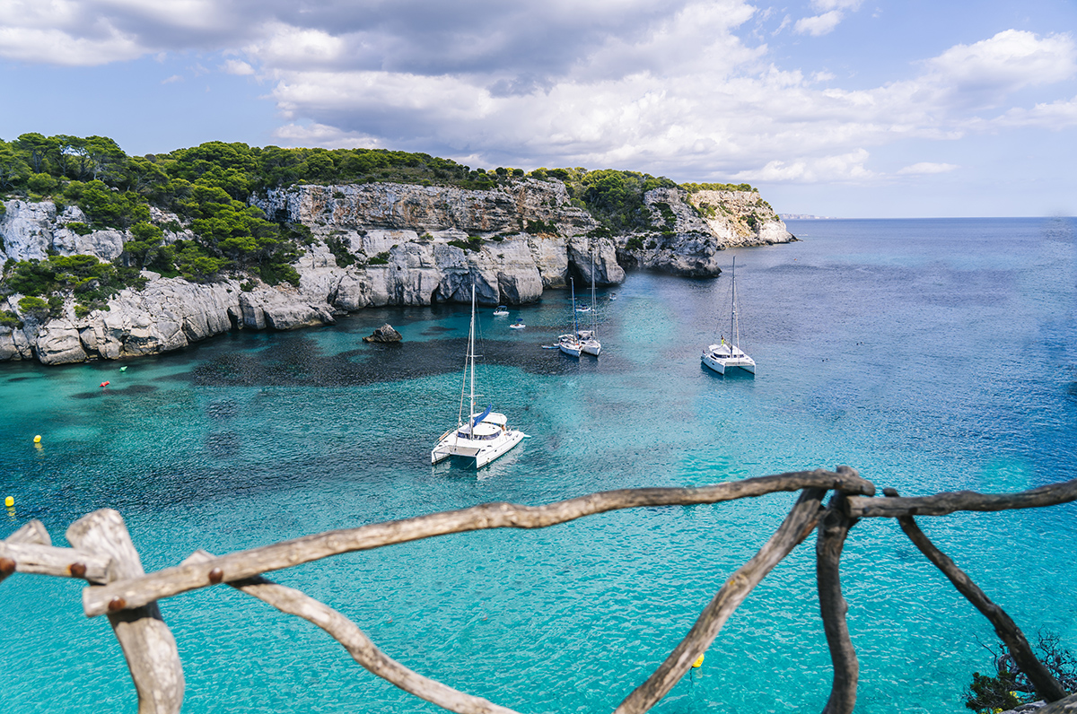 MENORCA, SPAIN. 3 SEPTEMBER 2020. Panoramic view of Cala Macarelleta with people on their boats enjoying a day of vacation.