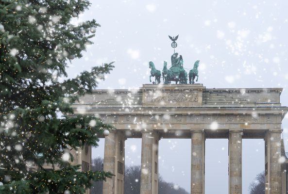 Bradenburg Gate with Christmas tree at winter day with falling snow, Berlin, Germany