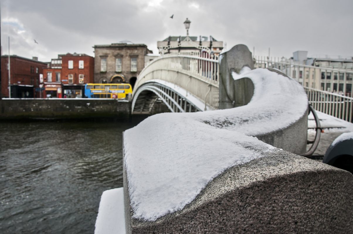 DUBLIN.IRELAND - February 28 , 2018: Ha’penny bridge over the Liffey river covered with snow as a result of a snow storm in Ireland.